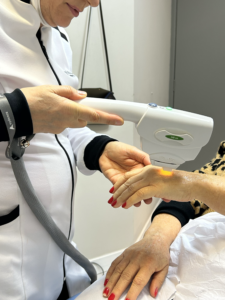 Dra. Raquel Milão aplicando tecnologia na mão de uma paciente