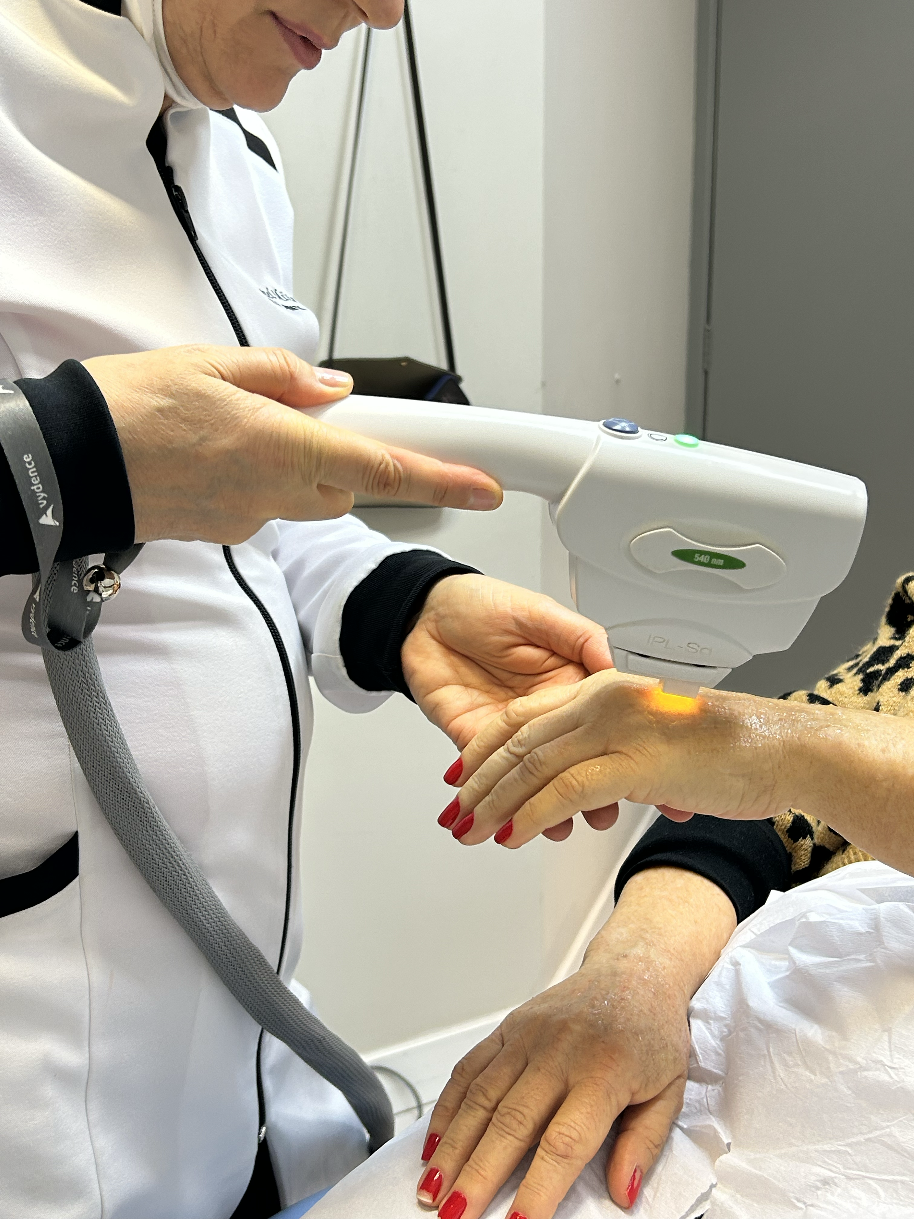 Dra. Raquel Milão aplicando tecnologia na mão de uma paciente